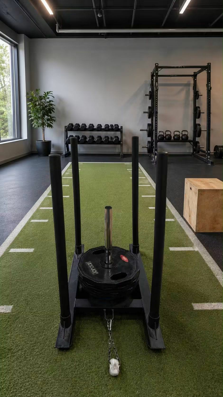 FitMe weight sled loaded with plates on a gym turf track