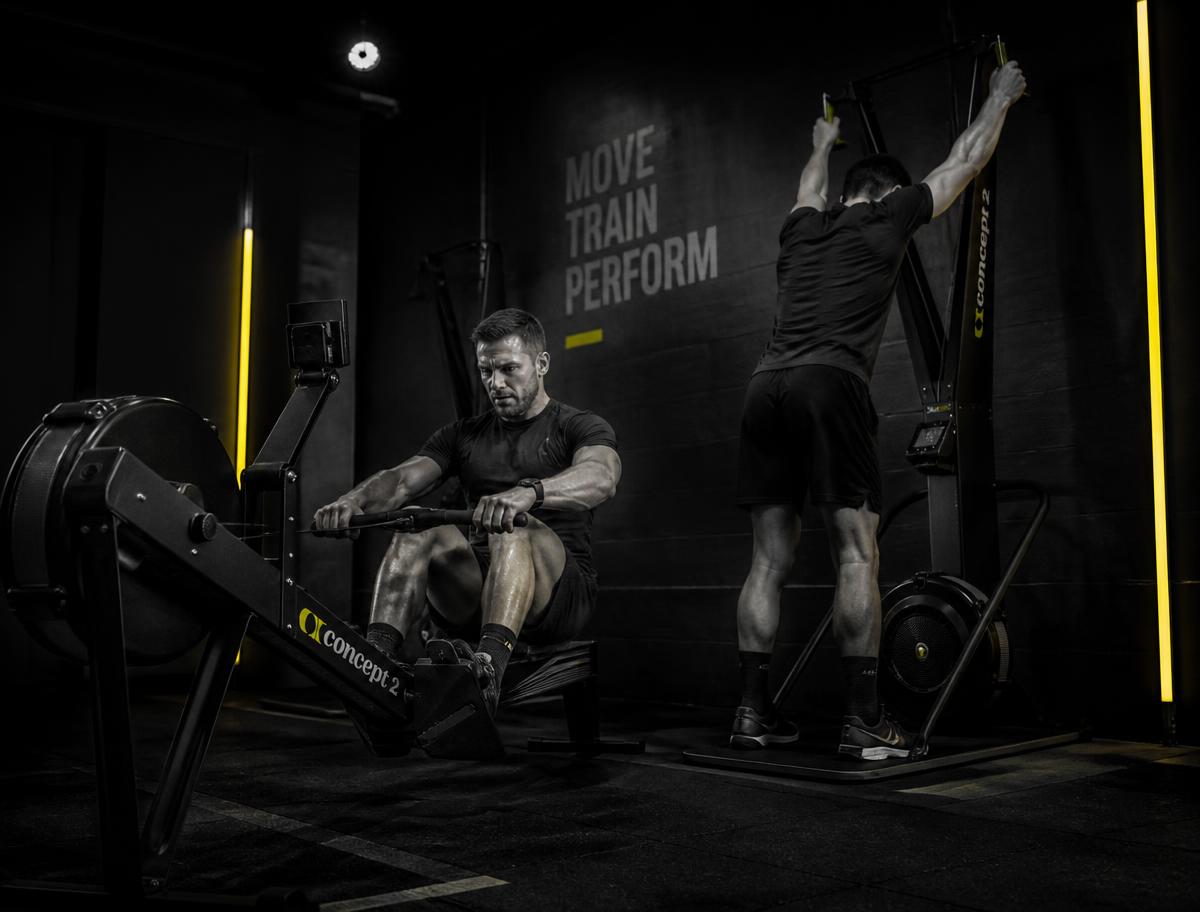 Athletes training on an air rower and ski erg